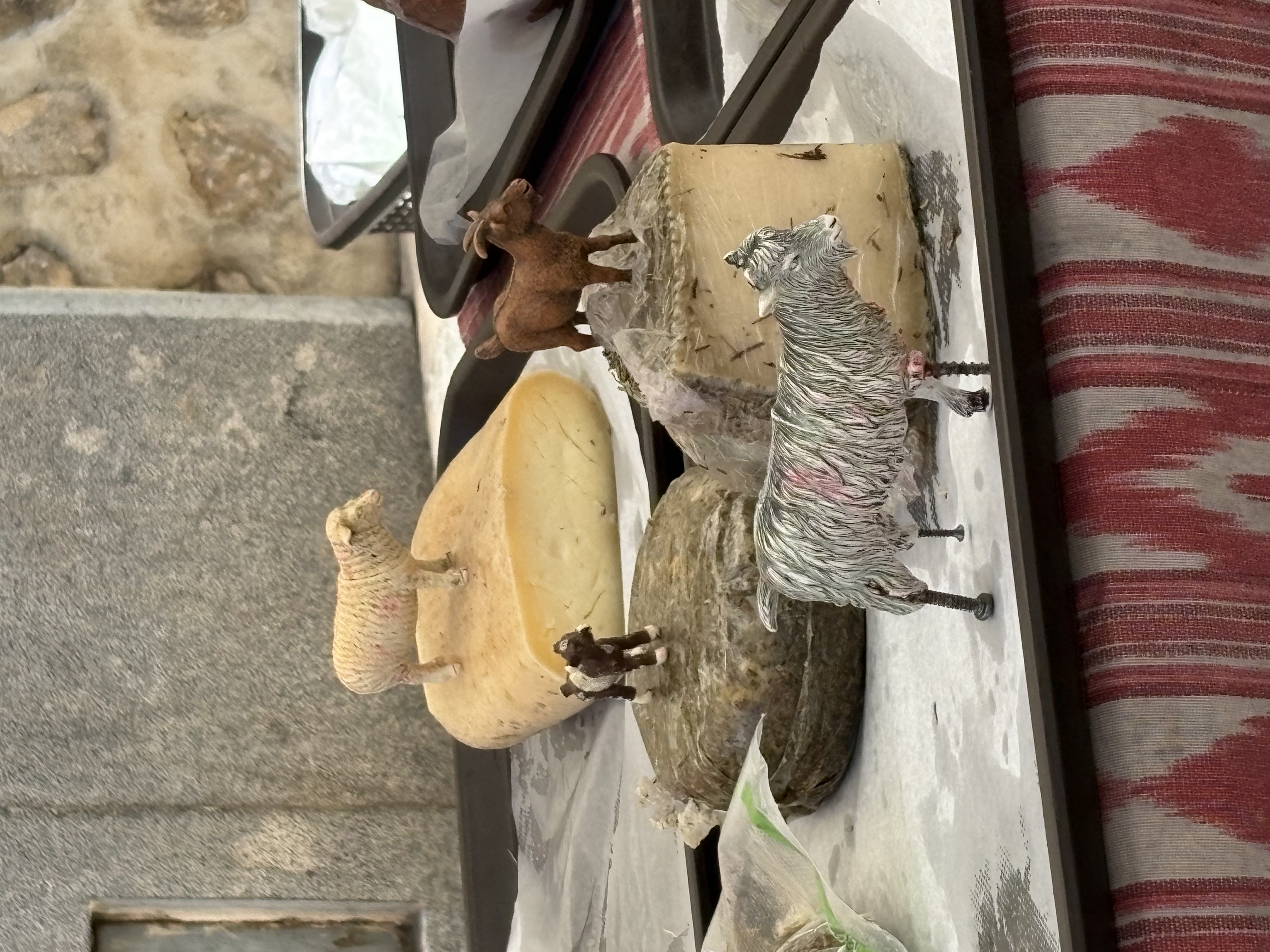 Miniature animals displayed on cheeses