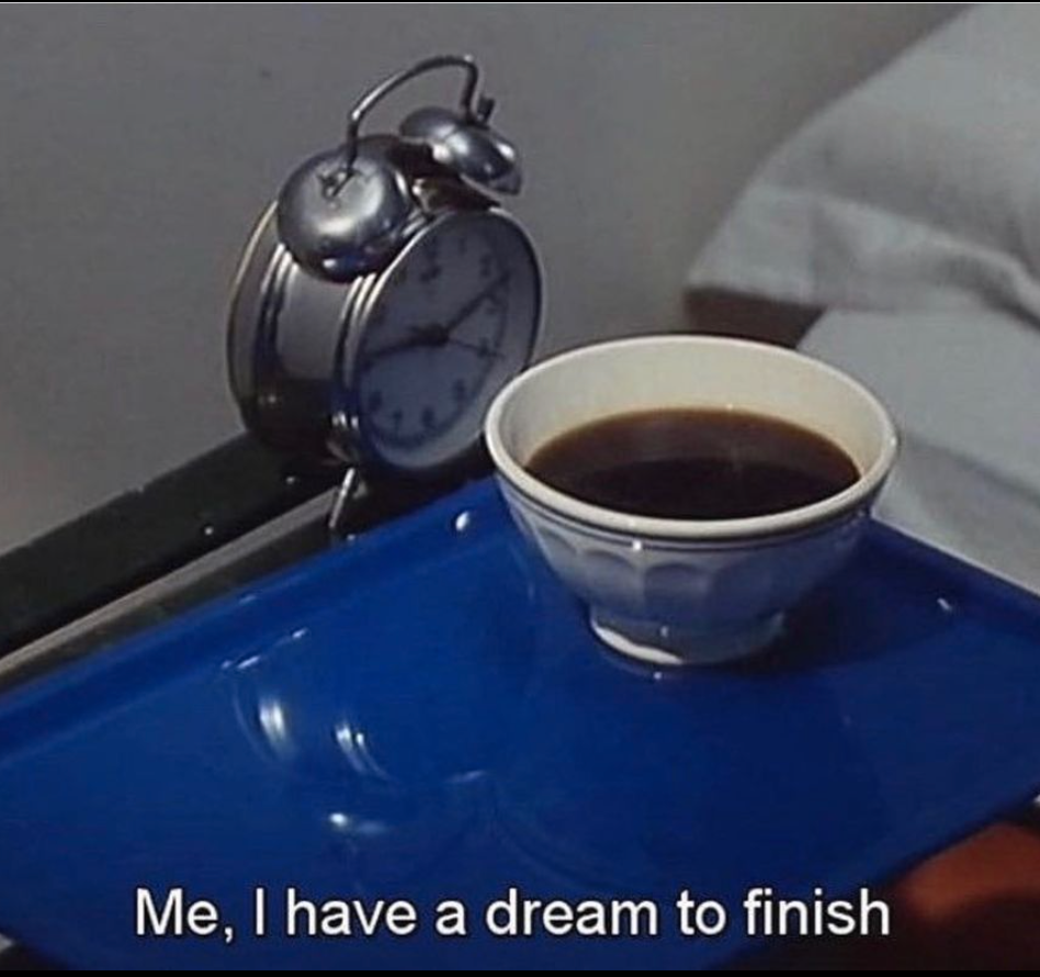 A film still of coffee and an alarm clock, captioned: Me, I have a dream to finish