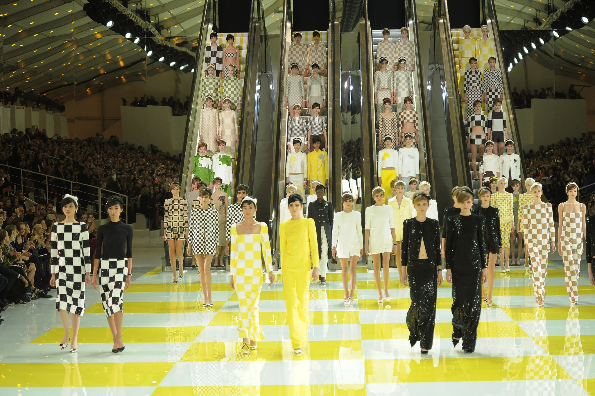 Models arranged across escalators at a fashion show